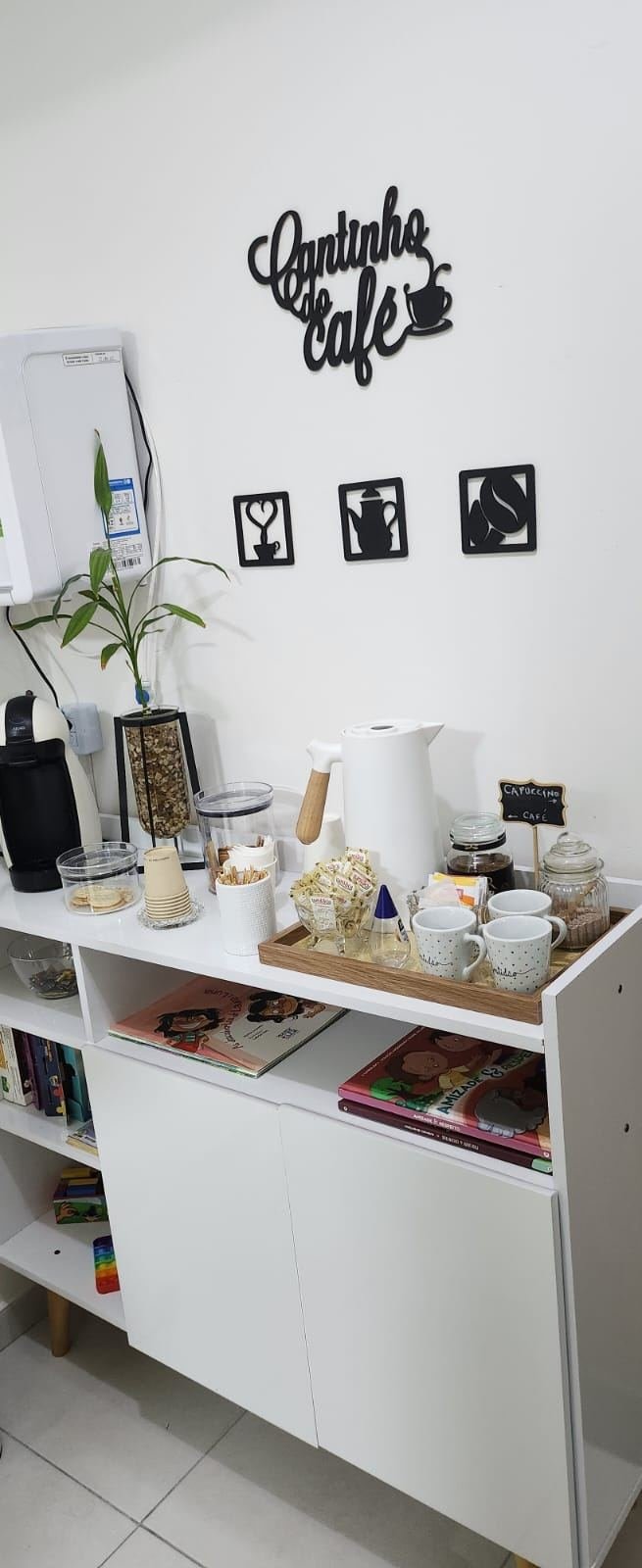 Cantinho do café do Espaço Integralle, com máquina de cápsulas e livros infantis